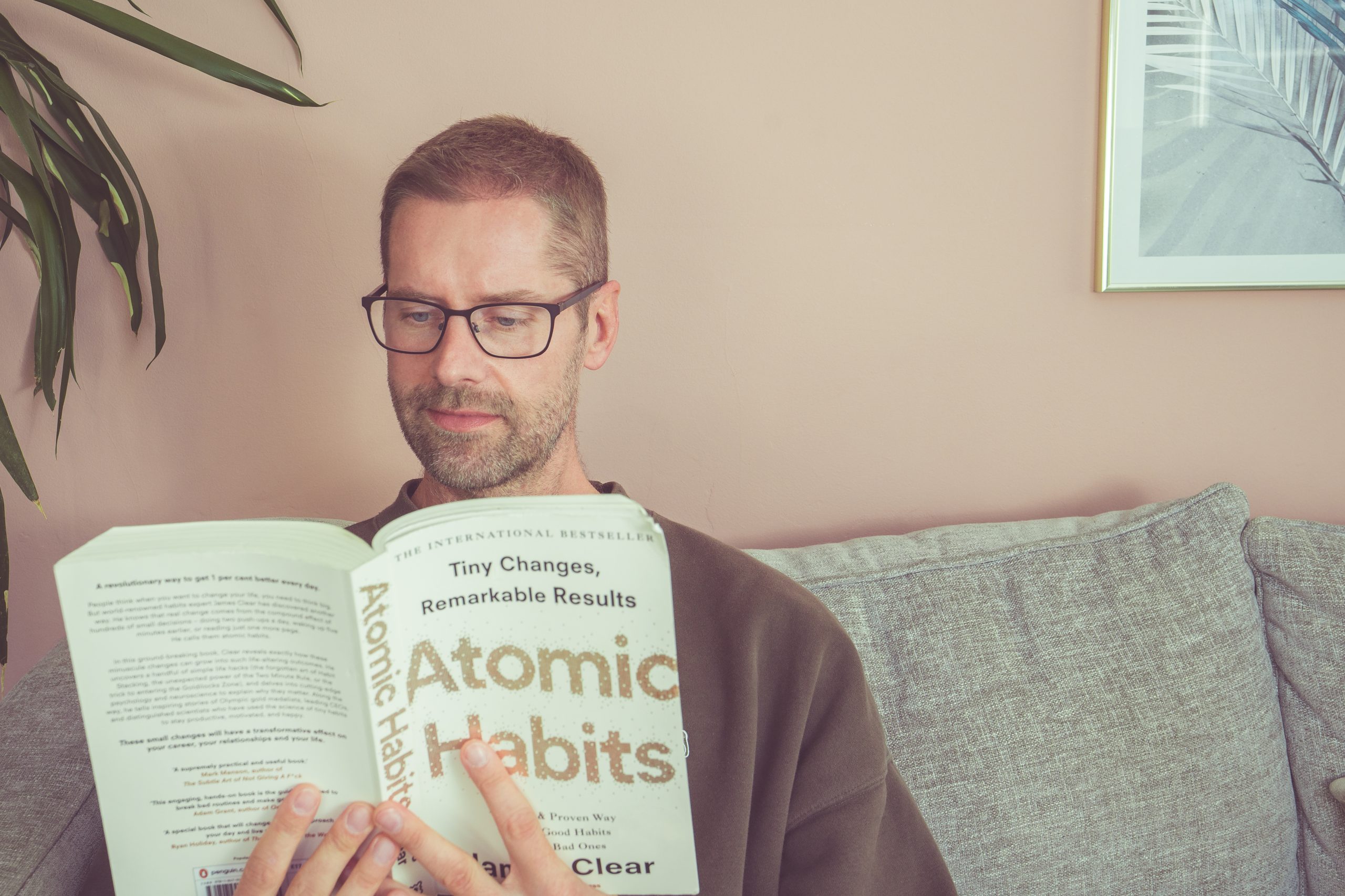 Mental Health and Wellbeing Strategies, a man sits calmy reading a book about positive habits and reflecting on his inner thoughts
