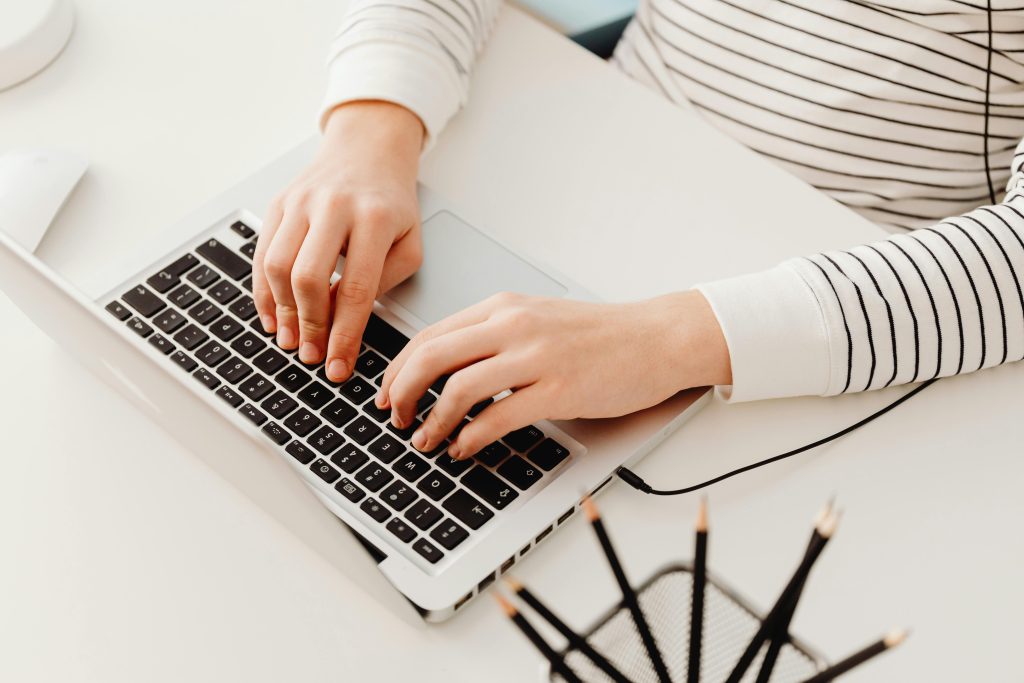 a person types on their laptop with focus and concentration, on their quest to become a productivity powerhouse
